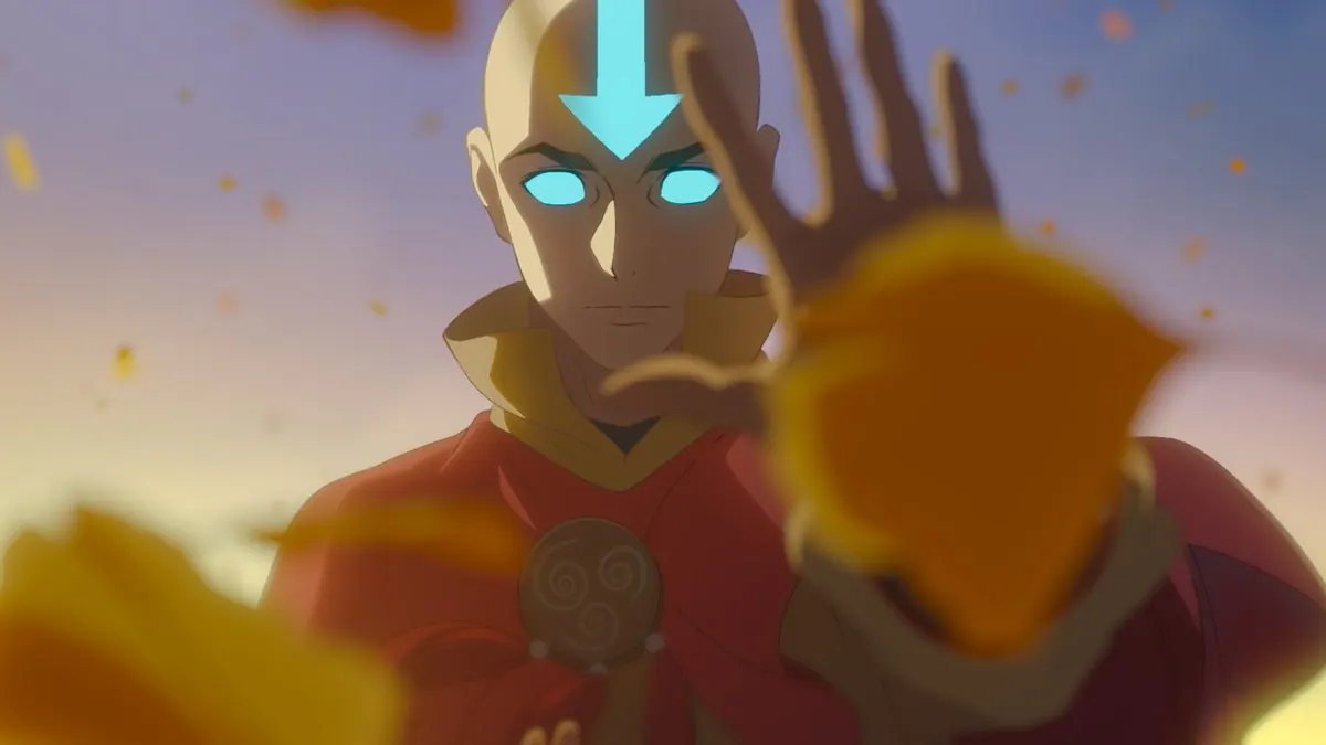 First-look still of adult Aang (Eric Nam) with glowing Avatar State eyes and arrow, hand raised, as orange leaves blow past