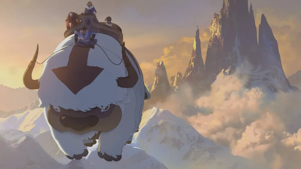 First-look still of Appa carrying Team Avatar over snowy mountain peaks and clouds