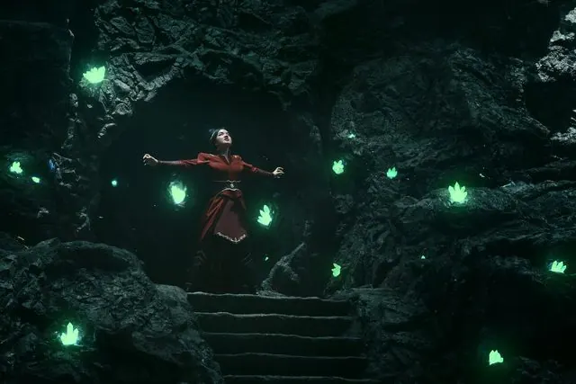 Season 2 still: Azula with arms outstretched in a cave lit by glowing green crystals