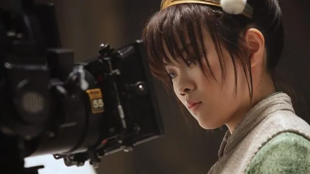 Season 2 behind the scenes: Miya Cech in Toph costume looking at a cinema camera on set