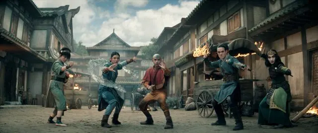Season 2 widescreen still: Toph, Katara, Aang, Sokka and Suki in fighting stances on a burning village street