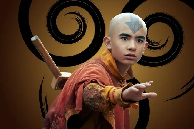 Season 2 character portrait: Gordon Cormier as Aang with his staff in front of the Air Nomad emblem