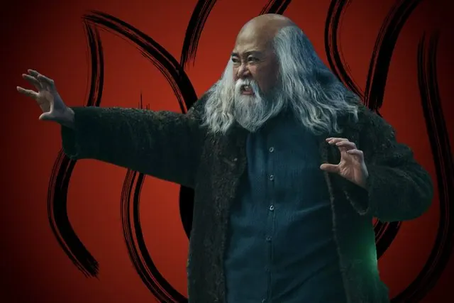 Season 2 character portrait: Paul Sun-Hyung Lee as Iroh, long gray hair and a dark coat, in front of the Fire Nation emblem
