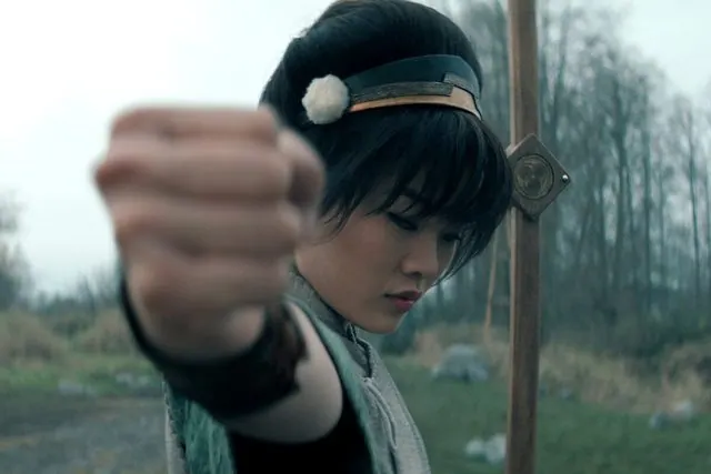 Season 2 still: Toph thrusting her fist toward the camera in a misty field