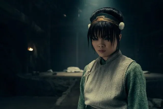 Season 2 still: Miya Cech as Toph in a torch-lit underground stone chamber
