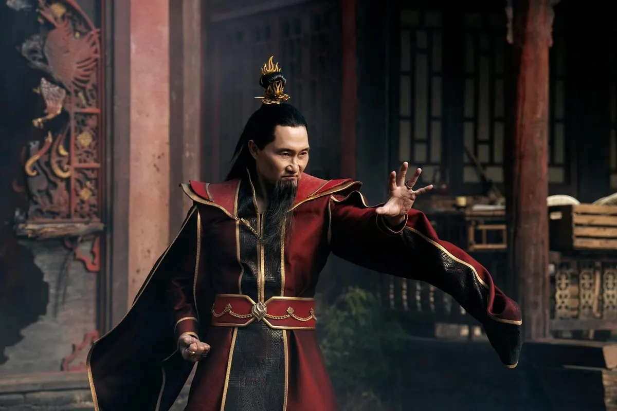 Season 3 first-look still (Sept 2026): Daniel Dae Kim as Fire Lord Ozai in red and gold robes and flame crown, in a firebending stance at the palace