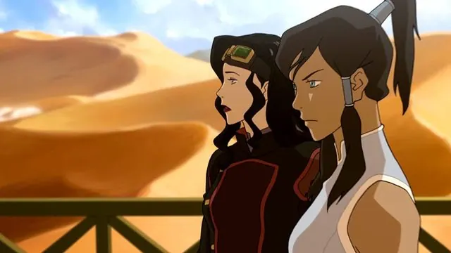 Book Three still: Asami, in goggles, and Korra at an airship railing over desert dunes